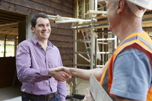 Customer Shaking Hands With Builder On Site